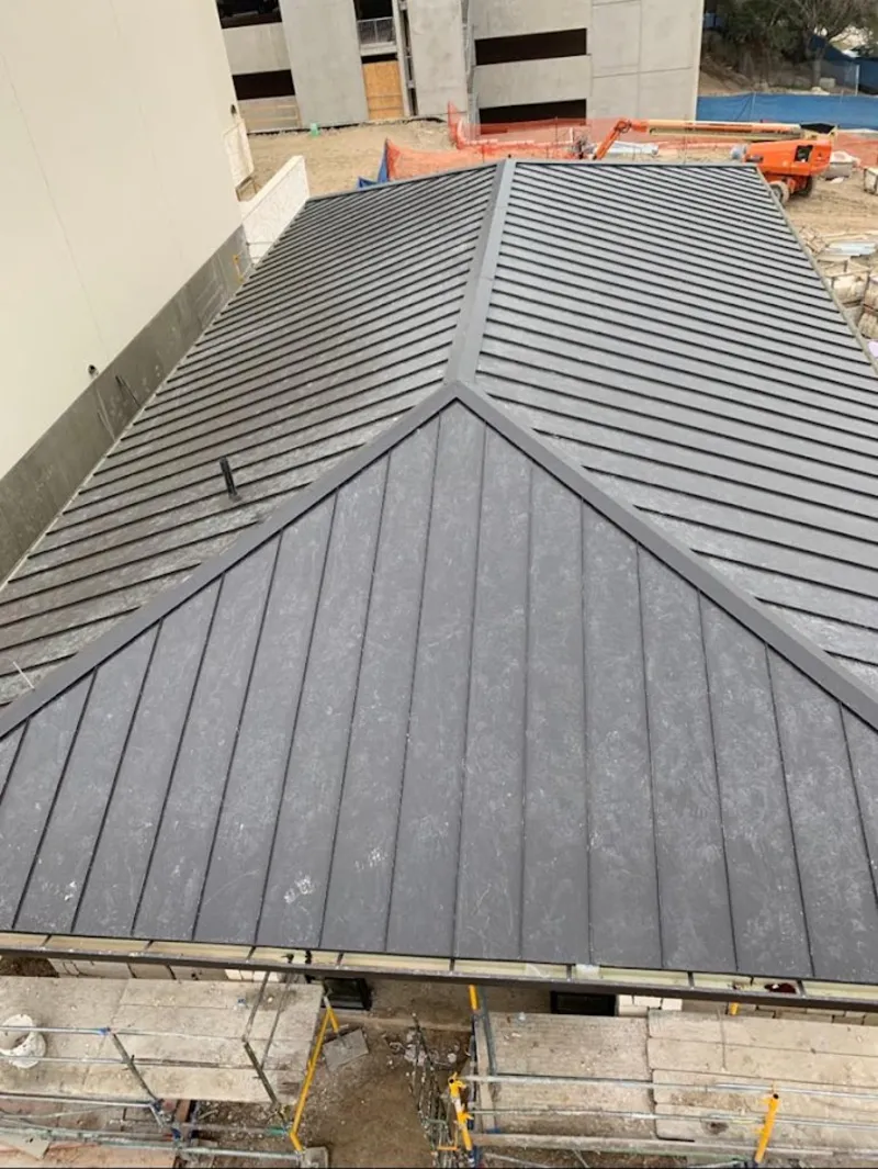 Commercial metal roof construction with crane equipment in Montrose